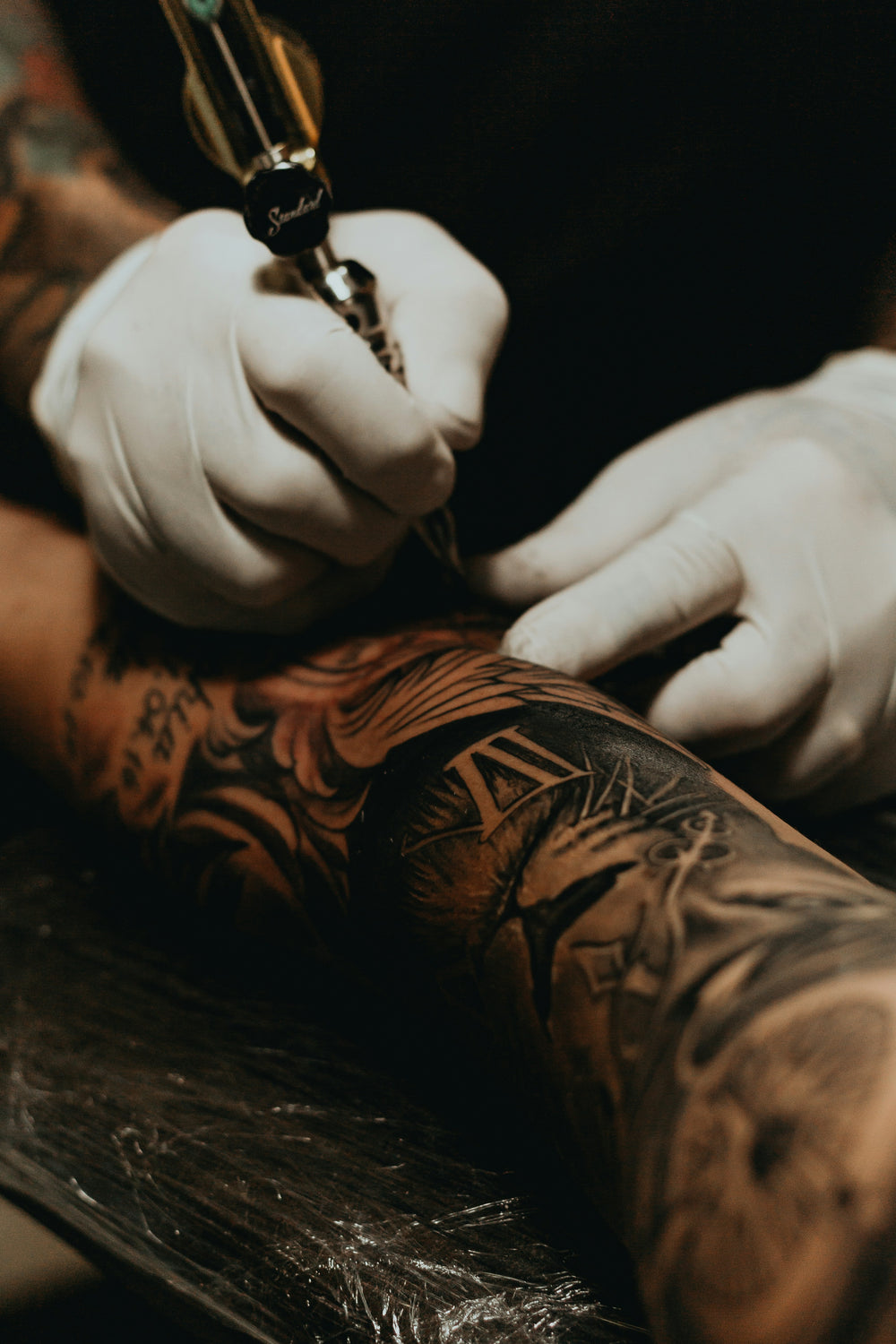 Tatoueur travaillant sur un client